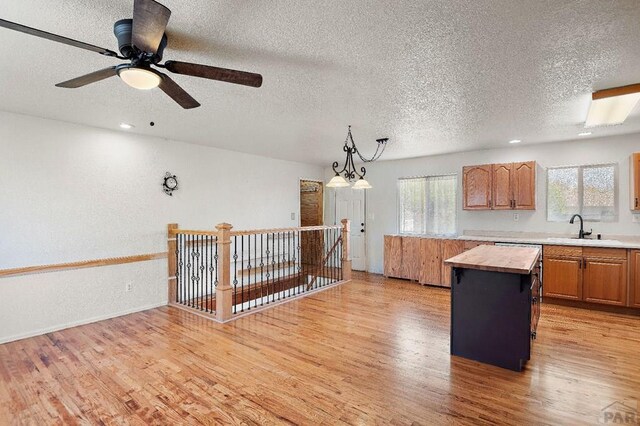 228 S Caddoa Dr, Pueblo West, CO 81007 - kitchen featuring a sink, wood counters, a textured ceiling, light wood-style flooring, and hanging light fixtures
