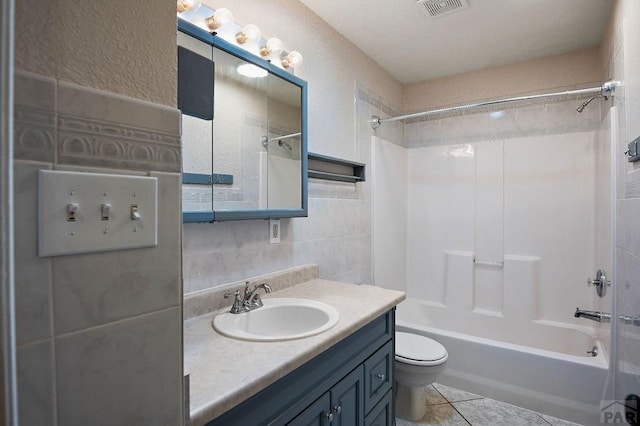 228 S Caddoa Dr, Pueblo West, CO 81007 - bathroom with tile patterned floors, vanity, shower / bath combination, toilet, and tile walls