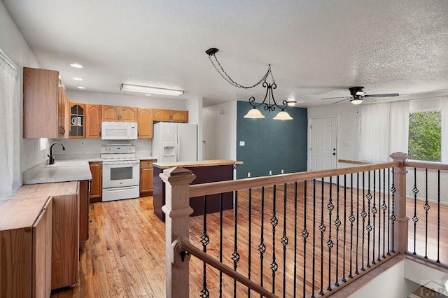 228 S Caddoa Dr, Pueblo West, CO 81007 - kitchen featuring white appliances, ceiling fan, light countertops, glass insert cabinets, and a textured ceiling