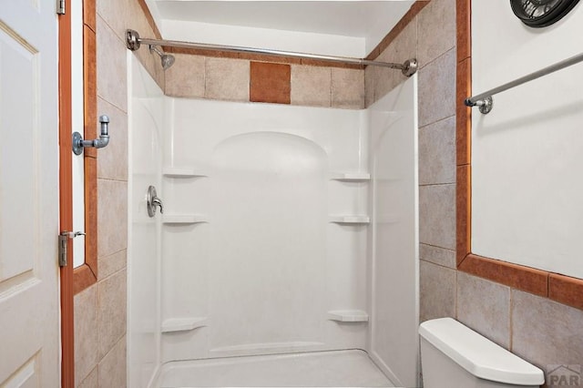 228 S Caddoa Dr, Pueblo West, CO 81007 - full bathroom with a shower stall, tile walls, and toilet