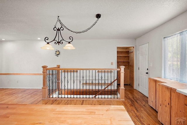 228 S Caddoa Dr, Pueblo West, CO 81007 - stairs with wood finished floors, a textured ceiling, and a chandelier