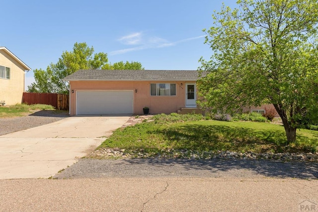 228 S Caddoa Dr, Pueblo West, CO 81007 - view of front facade featuring an attached garage, fence, and concrete driveway