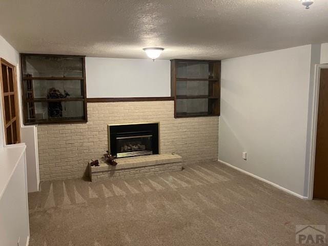 unfurnished living room with a brick fireplace, carpet flooring, and a textured ceiling