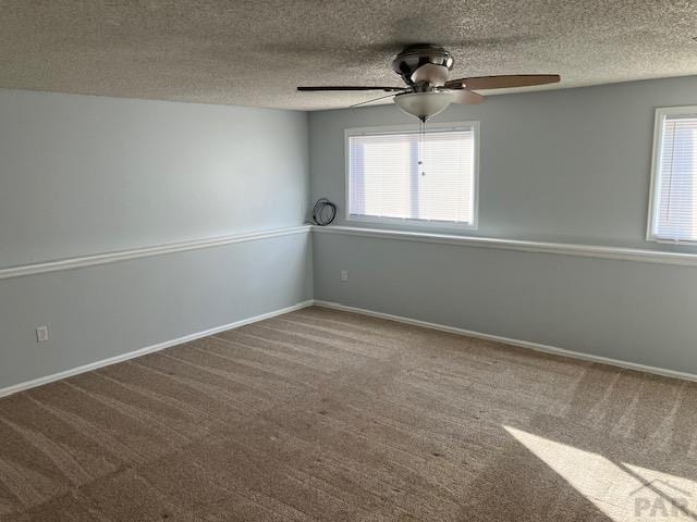 empty room with a ceiling fan, a textured ceiling, baseboards, and carpet flooring