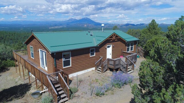 view of front of home featuring stairs, metal roof, and a mountain view