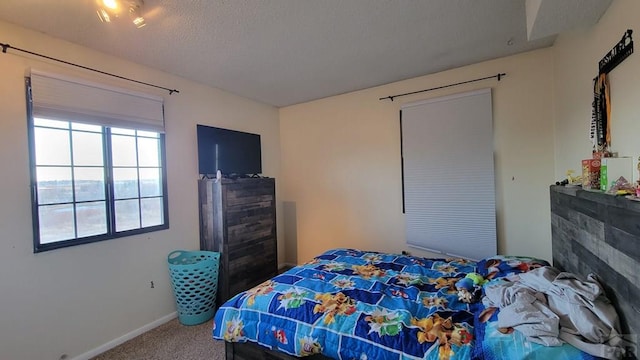 bedroom with carpet flooring, a textured ceiling, and baseboards