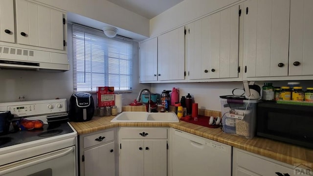 kitchen featuring light countertops, white cabinetry, a sink, ventilation hood, and white appliances