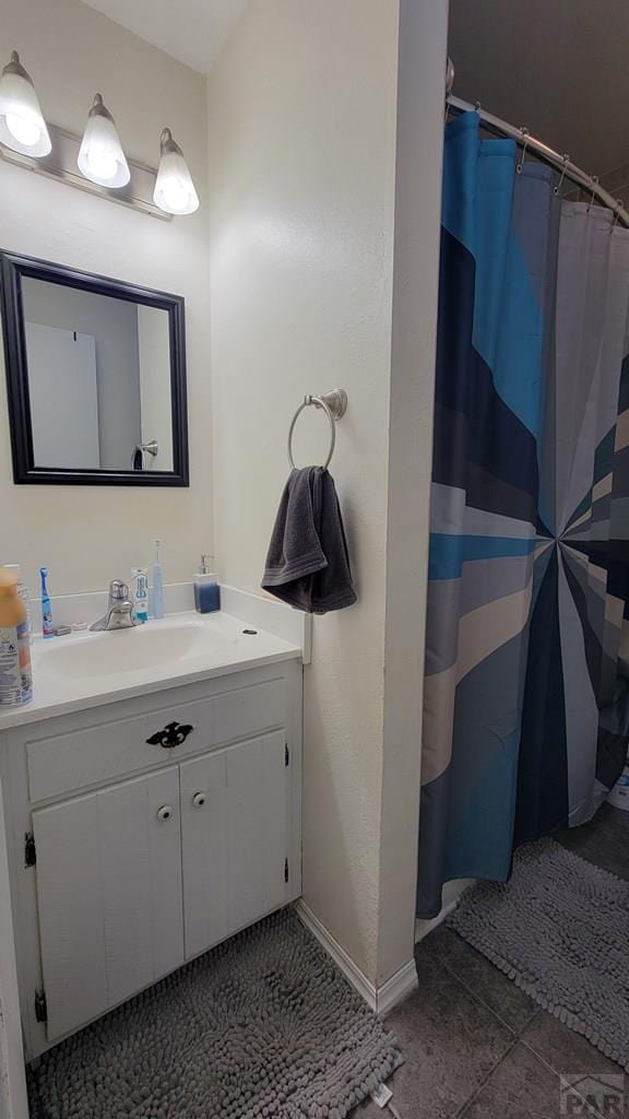 bathroom with curtained shower, tile patterned flooring, vanity, and baseboards