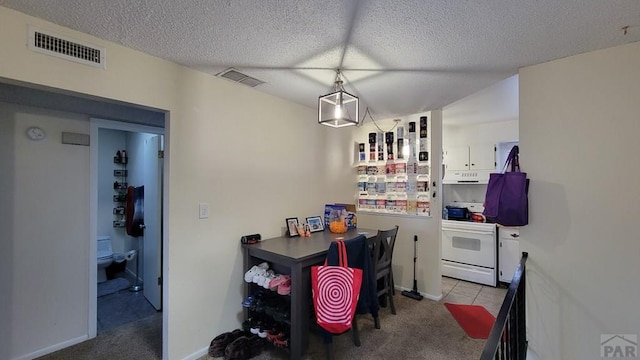 dining space featuring a textured ceiling, carpet, and visible vents