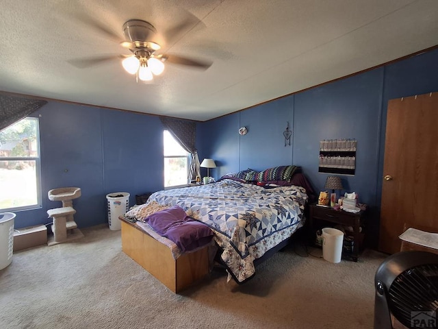 bedroom with a textured ceiling, carpet floors, and a ceiling fan