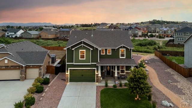 6740 Spruce Hill Ct, Colorado Springs, CO 80923 - view of front of house with a residential view, stone siding, concrete driveway, a porch, and an attached garage