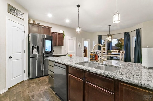 6740 Spruce Hill Ct, Colorado Springs, CO 80923 - kitchen with stainless steel appliances, dark wood finished floors, decorative light fixtures, light stone counters, and dark brown cabinetry