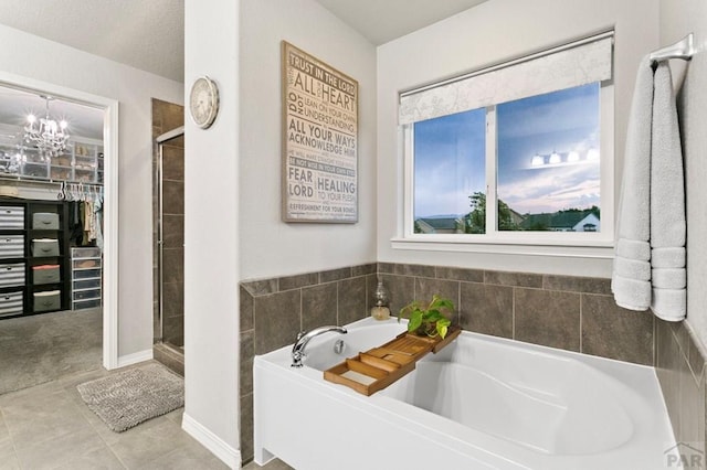 6740 Spruce Hill Ct, Colorado Springs, CO 80923 - bathroom with a bath, a stall shower, a spacious closet, and a chandelier
