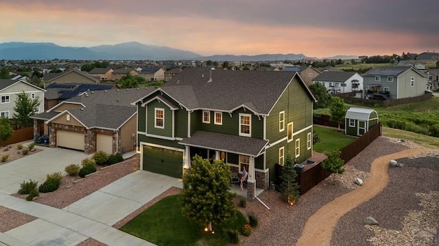 6740 Spruce Hill Ct, Colorado Springs, CO 80923 - view of front facade with a residential view, concrete driveway, roof with shingles, stone siding, and a mountain view