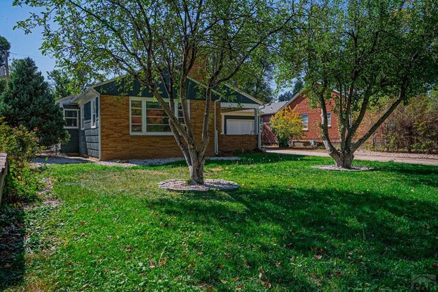 exterior space with a front yard and brick siding