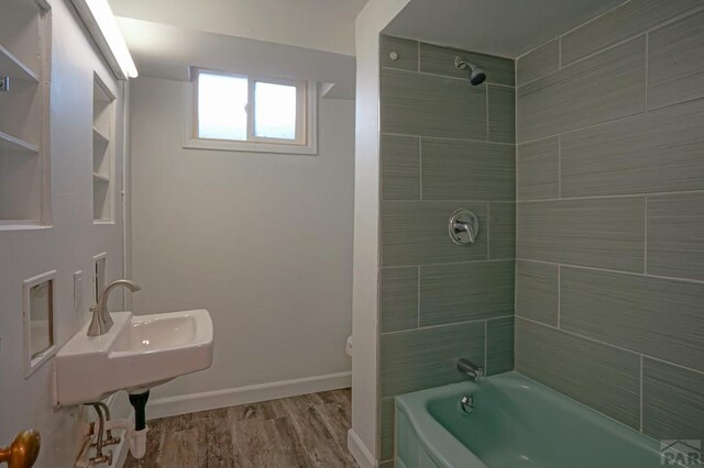 full bath with bathtub / shower combination, baseboards, toilet, and wood finished floors