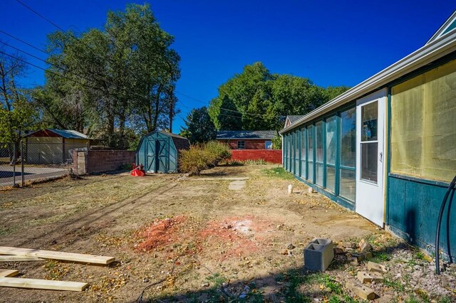 view of yard with a fenced backyard, an outdoor structure, and a shed