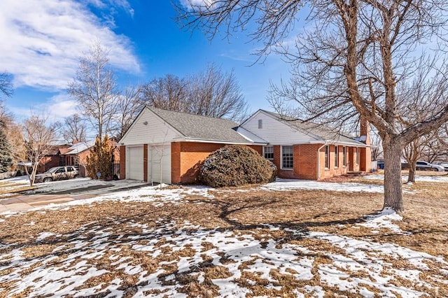 view of front of property featuring a garage, driveway, and brick siding