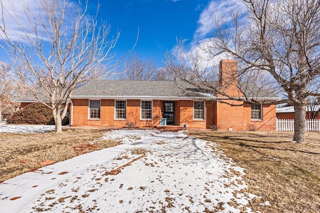 single story home featuring brick siding, fence, and a chimney