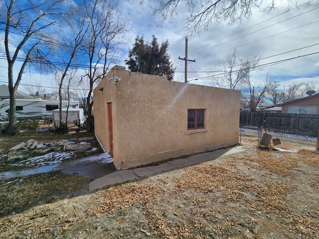 view of property exterior with fence and stucco siding