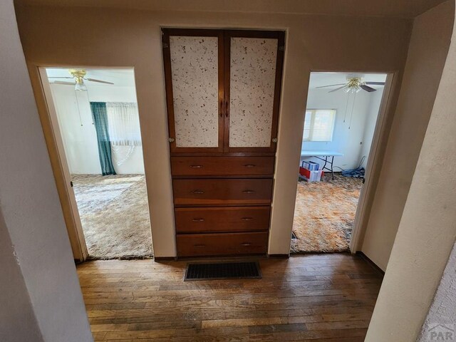 hall featuring visible vents and dark wood finished floors