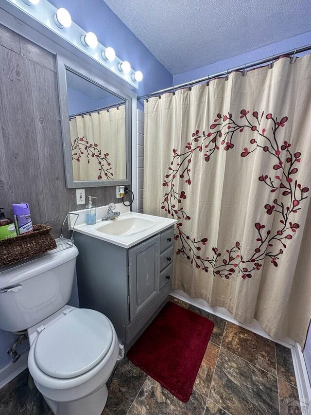 620 S 7th St, Springfield, CO 81073 - full bath featuring a textured ceiling, stone tile floors, vanity, and a shower with shower curtain