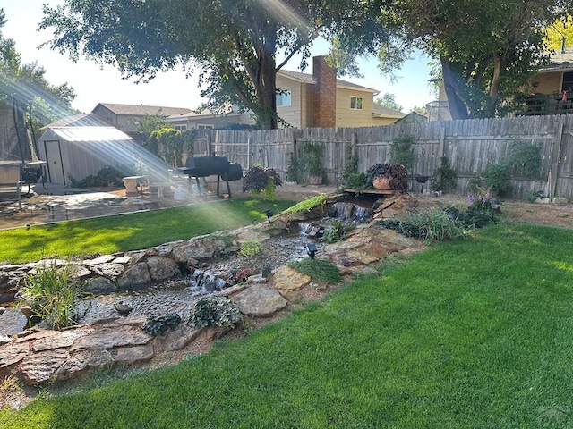 view of yard featuring a patio area, a trampoline, an outdoor structure, and fence