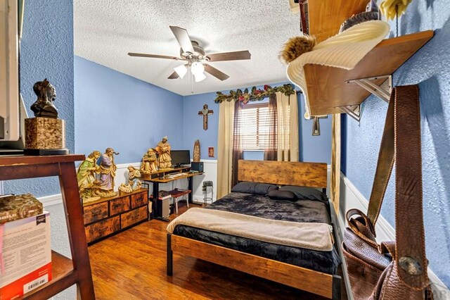 bedroom featuring a textured ceiling, wood finished floors, and a ceiling fan