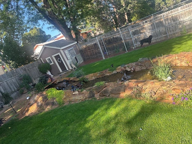 view of yard featuring an outdoor structure and a fenced backyard