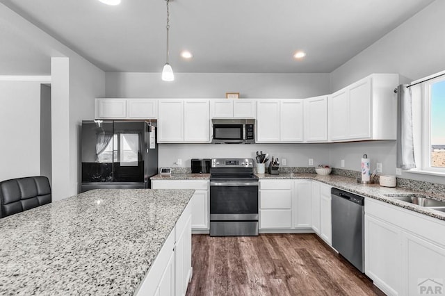 1437 Chuckwagon Ln, Pueblo West, CO 81007 - kitchen featuring stainless steel appliances, white cabinetry, light stone counters, dark wood finished floors, and recessed lighting