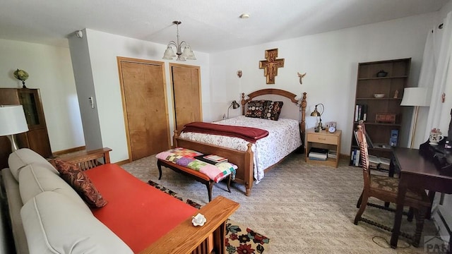 bedroom featuring a chandelier, light colored carpet, and two closets