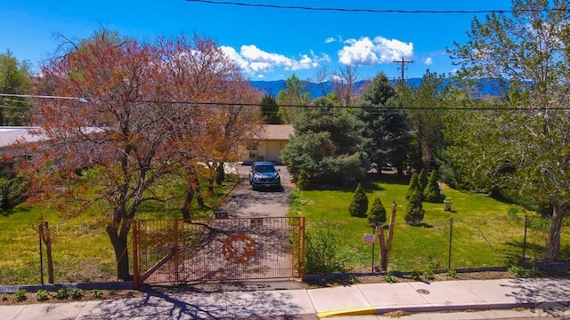 view of front facade featuring a gate, a front lawn, and a mountain view