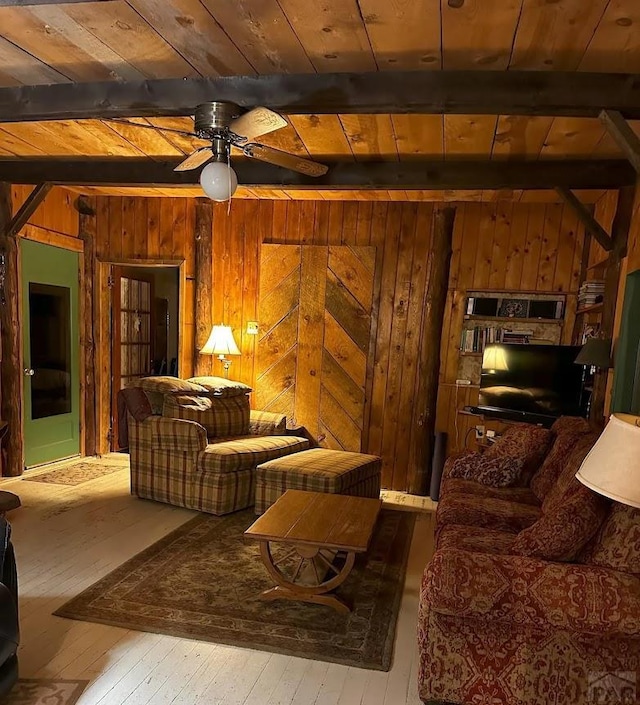 living room featuring hardwood / wood-style floors, beam ceiling, wood walls, and wood ceiling