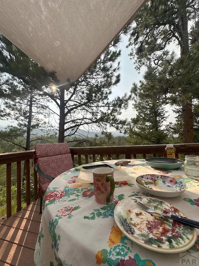 view of wooden balcony with a wooden deck and outdoor dining space