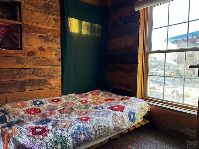 bedroom featuring wood walls and wood finished floors