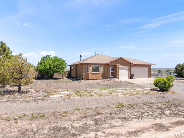 view of front of home featuring an attached garage, fence, and driveway
