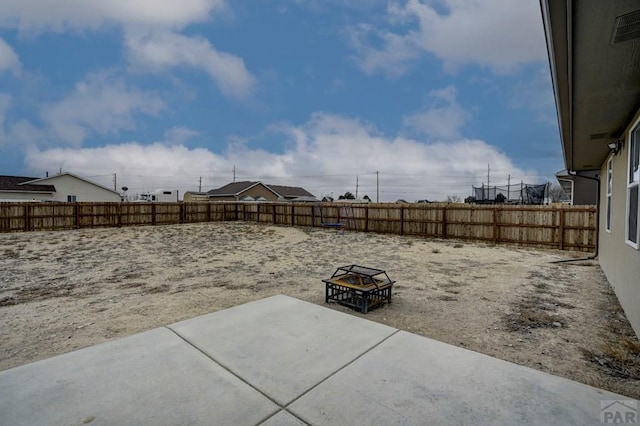 view of yard featuring an outdoor fire pit, a fenced backyard, and visible vents