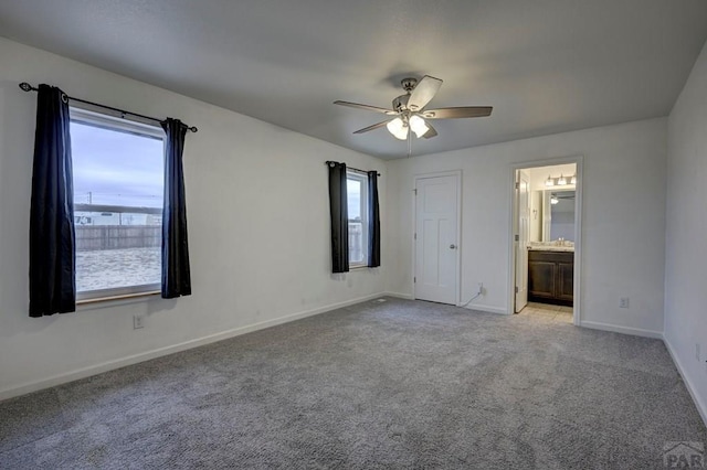 unfurnished bedroom with light carpet, ceiling fan, ensuite bathroom, and baseboards