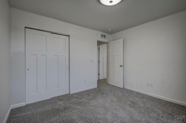 unfurnished bedroom with carpet floors, a closet, visible vents, and baseboards