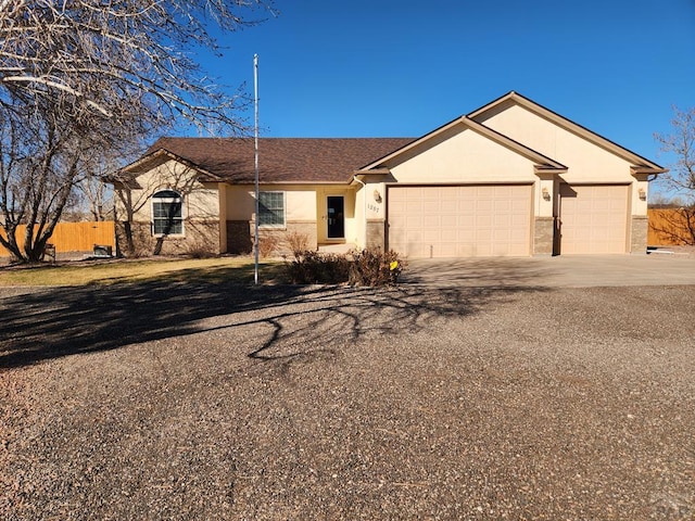 ranch-style home featuring stucco siding, an attached garage, and concrete driveway