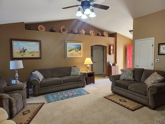 carpeted living room with arched walkways, a ceiling fan, and vaulted ceiling