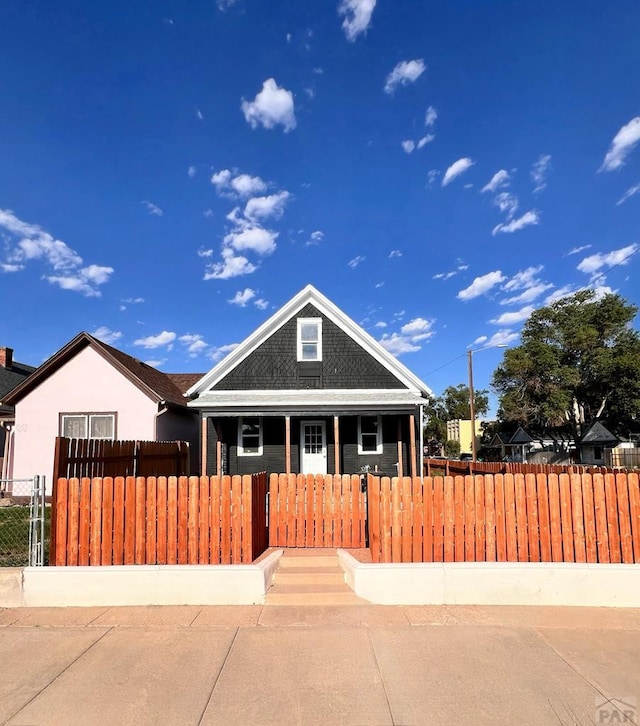 view of front of home with covered porch and a fenced front yard