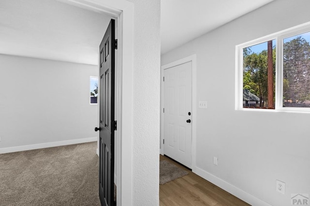 hallway featuring baseboards and wood finished floors