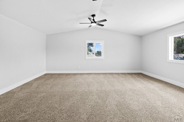 carpeted empty room featuring baseboards, a ceiling fan, and vaulted ceiling