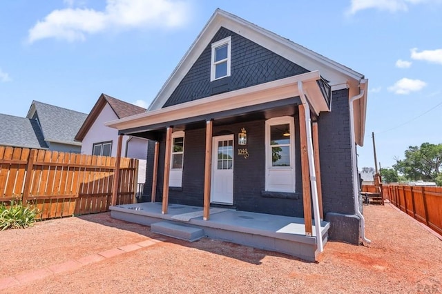 view of front of property featuring a porch and fence