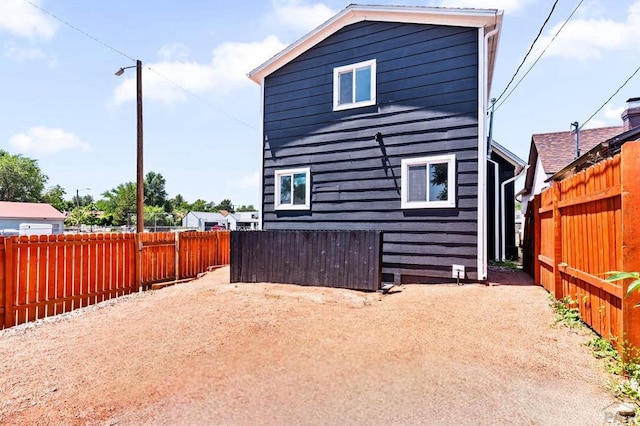 back of house with a fenced backyard