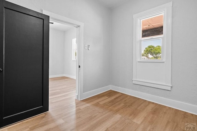 unfurnished room featuring light wood-type flooring and baseboards