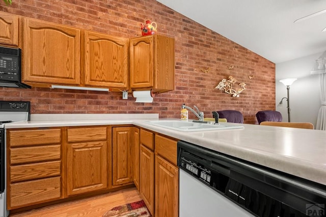 2106 Chatalet Ln Unit I, Pueblo, CO 81005 - kitchen with white appliances, lofted ceiling, brick wall, light countertops, and light wood finished floors