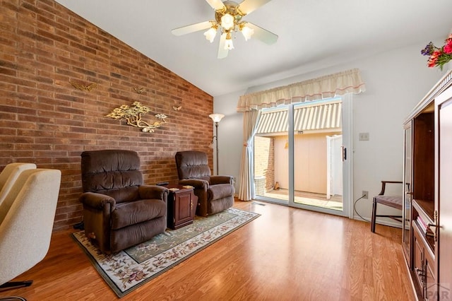 2106 Chatalet Ln Unit I, Pueblo, CO 81005 - sitting room with wood finished floors, lofted ceiling, ceiling fan, and brick wall