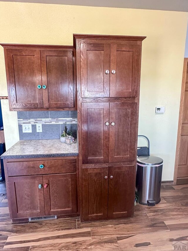 room details with backsplash and wood finished floors